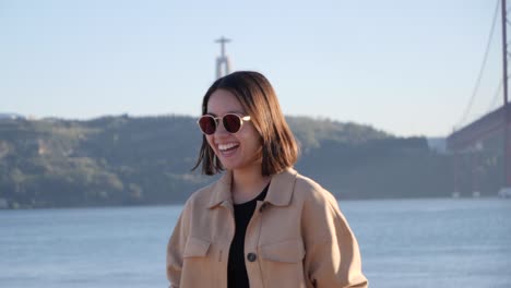 Happy-and-smiling-Thai-tourist-in-front-of-landmark-statue-Cristo-Rei-in-Lisbon