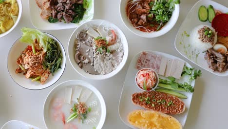 Male-hand-spinning-Vietnamese-noodle-soup-into-visually-appealing-flat-lay-composition