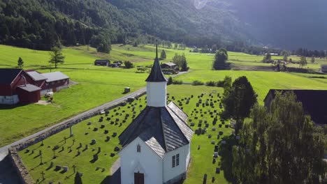 Loen-church-at-sunrise---Morning-reverse-aerial-from-church-tower-and-back---Revealing-countryside-farmland-and-local-cemetery