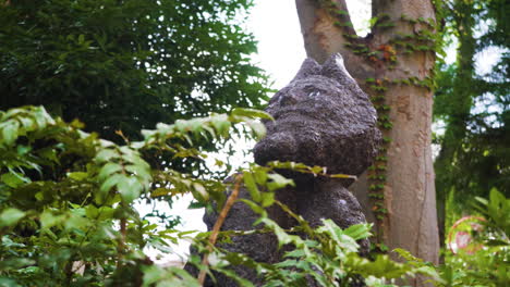 Die-Japanische-Statue-Eines-Fabelwesens-Steht-Inmitten-Der-Natur-In-Einem-Friedlichen-Grünen-Tokio-Park