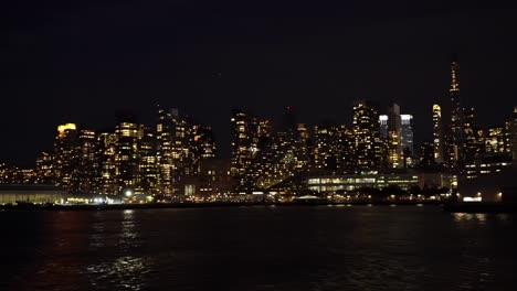 Panoramablick-Von-Einer-Fähre-Auf-Die-Skyline-Von-New-York,-Die-Nachts-Beleuchtet-Ist