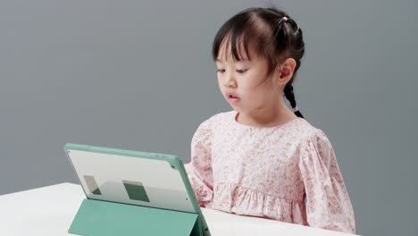 Kind-Unterhalten-Sich-Mit-Digitalem-Tablet-Auf-Dem-Tisch