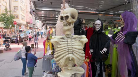 Adornos-Decorativos-Con-Tema-De-Halloween-Del-Cráneo-Mitológico-Parca-Fuerza-Personificada-Como-Muerte,-Se-Venden-En-Un-Puesto-Días-Antes-De-Halloween-En-Hong-Kong