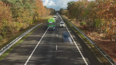 Transporte-Terrestre-Acelerando-En-La-Autopista-A28-En-Holanda-Con-Follaje-Otoñal-En-Un-Día-Soleado