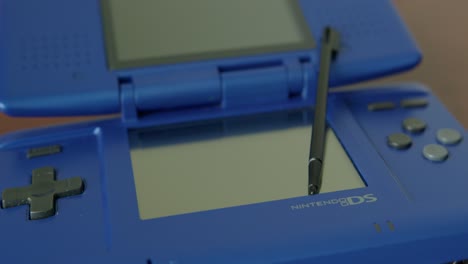 Close-Up-Pan-Right-of-a-Blue-Nintendo-DS-with-a-Stylus