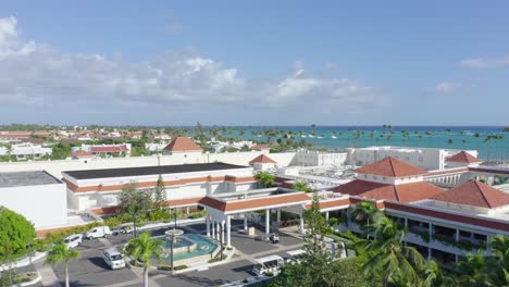 Vista-Aérea-Ascendente-De-Paradisus-Palma-Real-Resort-Con-Estacionamiento-Y-Hermoso-Mar-Caribe-De-Fondo
