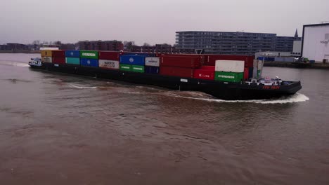 Steuerbord-Luftaufnahme-Des-FPS-Rijn-Schiffes,-Das-An-Einem-Bewölkten-Nachmittag-Container-Auf-Dem-Fluss-Noord-Transportiert