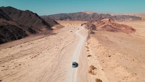 A-car-driving-in-the-desert-in-a-path-through-the-mountains-in-Israel