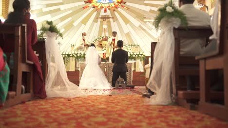 Newlyweds-Kneel-At-The-Altar-In-The-Catholic-Church-At-The-Wedding-|-Bride,-and-Groom-|-SLOW-MOTION-|-Priests-Walk-In