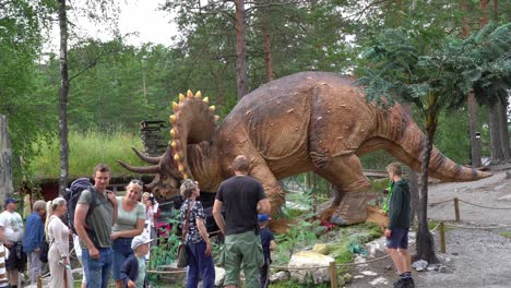 Recreación-De-Triceratops-Horridus-En-El-Parque-Temático-Dinosauria-Noruega---Familias-Caminando-Alrededor-Del-Modelo-De-Dinosaurio-De-Tamaño-Real-Con-Cabeza-Móvil---Clip-Estático