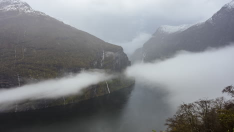 Clouds-Moving-Over-Geirangerfjord-Between-Mountains-With-Waterfalls-From-Ornesvingen-Viewpoint-In-Norway