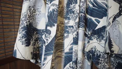 Schwenken-Sie-Den-Kimono,-Der-Vor-Einer-Japanischen-Holzwand-Hängt-–-Kleid-Mit-Dem-Großen-Wellenmuster-Von-Kanagawa