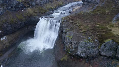 Aerial-descending-shot-of-crashing-water-of-waterfall-into-Sela-River---Iceland,Europe