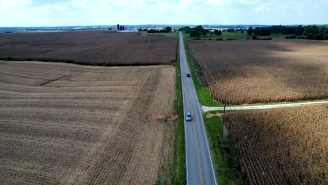 Car-on-roadway-aerial-through-cornfield-in-kentucky