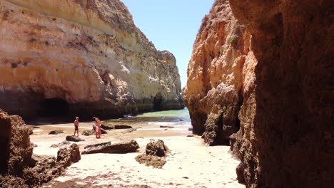 Praia-Dos-Tres-Irmaos-Strand,-Algarve,-Portugal---Drohnenaufnahme-Aus-Der-Luft,-Die-Durch-Ein-Loch-In-Den-Felsformationen-Zum-Strand-Und-Zum-Meer-Fliegt