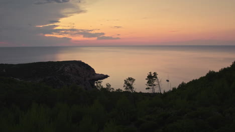 Ibiza-island-twilight-reflections,-boats-at-sea,-revealing-drone-shot