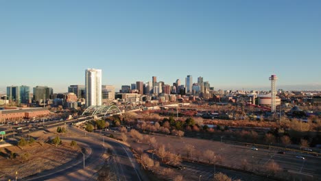 Drohnen-Luftaufnahme-Der-Skyline-Der-Innenstadt-Von-Denver,-Colorado,-Die-Während-Des-Sonnenuntergangs-Zur-Goldenen-Stunde-Rückwärts-Fliegt