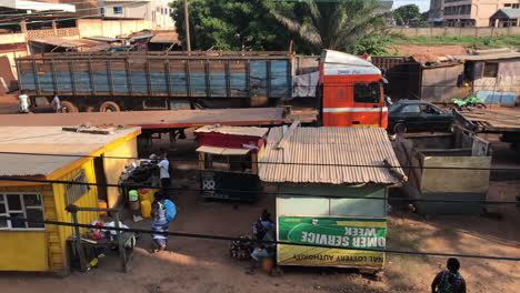 Barrio-Africano-Pobre-Con-Chozas-Y-Un-Remolque-De-Carga,-Ghana