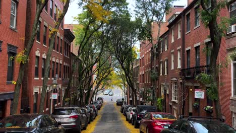 Streets-in-Beacon-Hill,-Boston-with-cars-and-fall-foliage-trees-in-USA---tilt-view