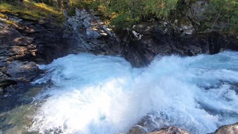 Agua-Torrencial-De-Un-Río-De-Montaña-Que-Cae-En-Un-Desfiladero-Con-Rocas-Escarpadas-Y-Escarpadas