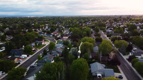 Aerial-landscape-view-rising-over-a-suburban-green-area,-at-dusk