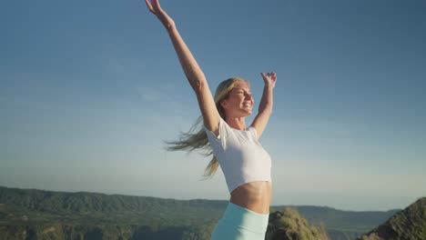 Female-hiker-reaching-top-raising-arms-in-air-happy-face-expression-and-sense-of-freedom