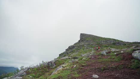 Grupo-De-Tres-Excursionistas-Que-Descienden-De-Una-Empinada-Montaña-Rocosa-De-Segla,-Senja,-Noruega