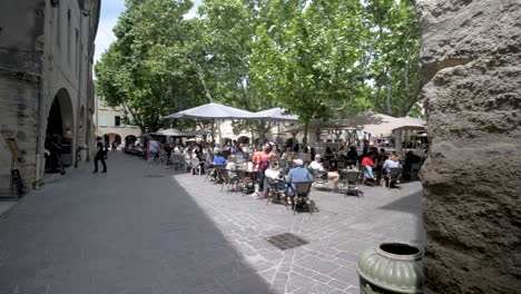People-enjoying-an-outdoor-cafe-in-the-main-Herbs-town-square,-Pan-left-Slow-Motion-shot