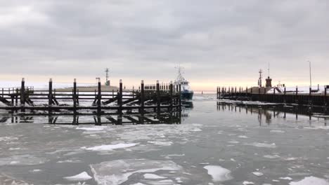 Ship-entering-a-harbor-full-of-ice-on-a-cloudy-winter-day