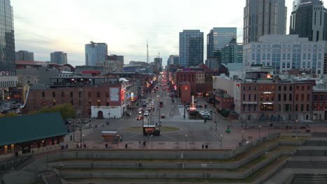 Aerial-drone-view-approaching-the-Broadway-street,-dusk-in-Nashville-city,-USA
