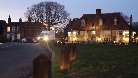 Evening-shot-of-traffic-with-dazzling-headlights-in-a-pretty-Kent-village-in-England