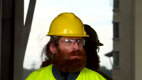 Portrait-of-a-Construction-Worker-smoking-in-extreme-slow-motion-outdoors-on-break-at-job-site-in-urban-city-setting-with-sky-reflection-as-background