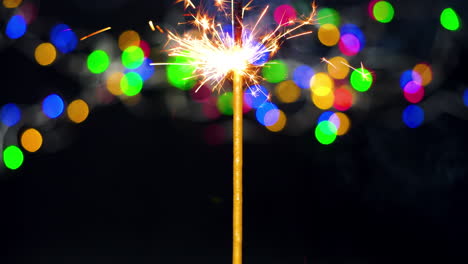 Sparklers-giving-off-sparks-and-light-with-colorful-bokeh-background