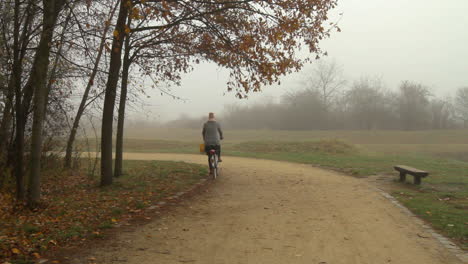 Un-Ciclista-Pasa-Por-Un-Parque-De-La-Ciudad-De-Niebla