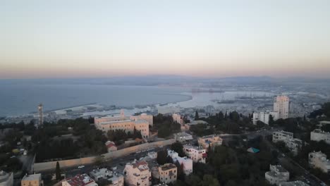 View-from-the-overhang-of-the-port-city-and-the-UNESCO-landmark-with-boats-and-traffic-on-a-quiet-evening,-Haifa,-Israel
