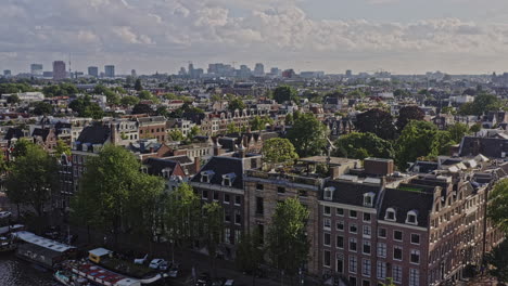 Amsterdam-Netherlands-Aerial-v35-low-level-flyover-neighborhoods-of-jodenbuurt,-grachtengordel-and-de-weteringschans-capturing-cityscape-of-dutch-townhouses-and-boats-on-water-canal---August-2021