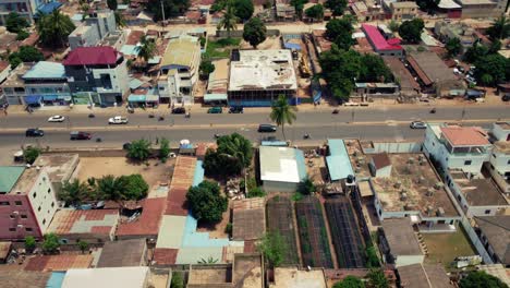 Cinematic-Top-down-rising-Aerial-View-of-African-City-neighborhood-road-traffic,-Lomé,-West-Africa