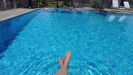 woman-legs-splashing-on-a-blue-pool