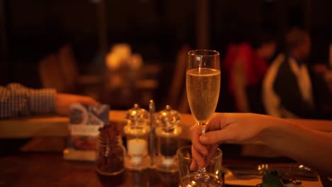 Couple-in-luxury-restaurant-cheers-with-glasses-of-champagne