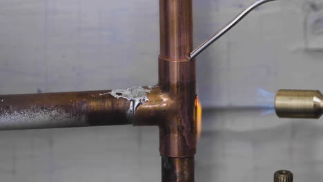 Welding-the-top-and-bottom-of-a-copper-pipe-tee-fitting-during-a-burst-pipe-DIY-home-repair