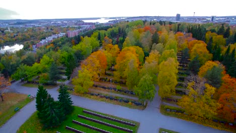 Drone-rising-over-a-cemetary-showing-the-cityscape-of-Tampere-in-Finland