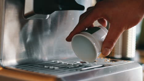 Close-up-of-Hand-pouring-hot-water-out-of-espresso-cup