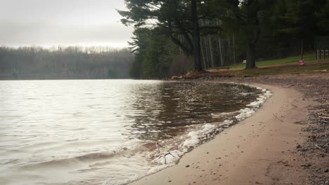 Gentle-water-lapping-onto-sandy-shore-at-public-beach