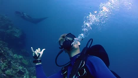Scuba-diver-interacts-with-a-curious-giant-manta-in-the-water