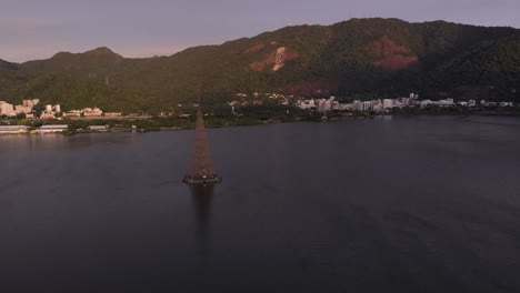 Aerial-movement-forward-over-the-Rio-de-Janeiro-city-lake-with-the-floating-Christmas-tree-of-2018-in-the-middle-revealing-the-Corcovado-mountain-with-the-Christ-statue-on-top-at-sunrise-behind-it