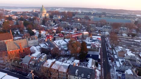 Aerial-wide-shot-of-historic-downtown-Annapolis-and-US-Naval-Academy-at-sunrise-with-purple-and-golden-hues