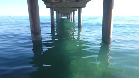 amazing-shot-flying-under-pier-with-drone,-risky-flight-with-high-risk-of-losing-drone