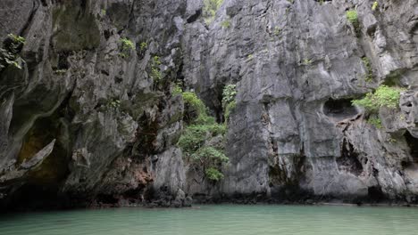 Slow-motion-wide-angle-tilt-shot-of-limestone-cliffs-in-Secret-Lagoon-in-El-Nido,-Palawan,-the-Philippines