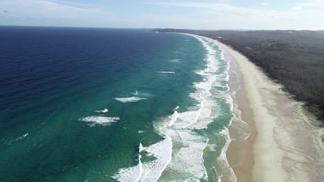 Aerial-top-view-of-a-white-sand-beach,-waves-rolling-and-nice-vegetation