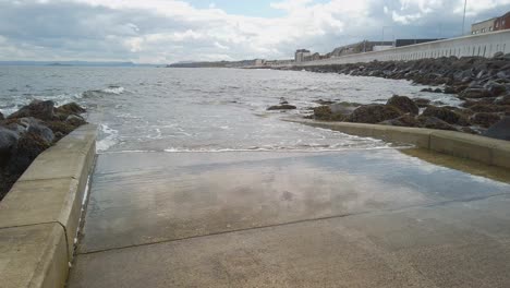 Boat-slipway-from-promenade-to-water-with-lapping-waves